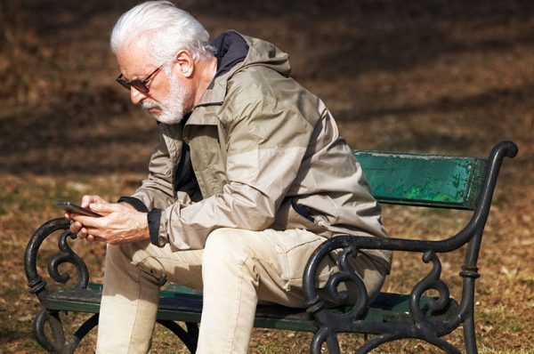 phone scam advice, eldery man looking at mobile phone